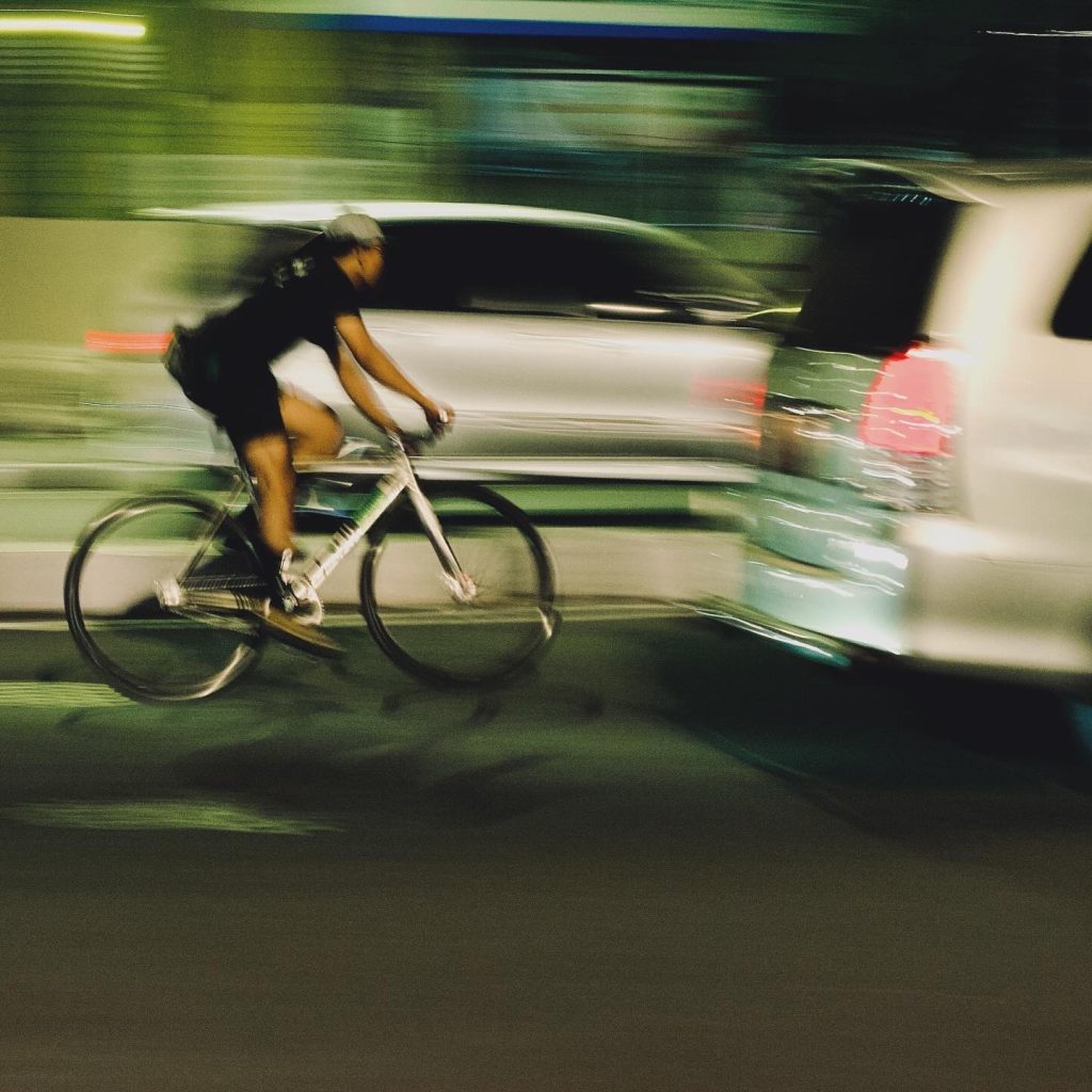 fixed gear bike also known as fixie drive fast trough traffic jam at yogyakarta city at night so the picture became blur or blurry