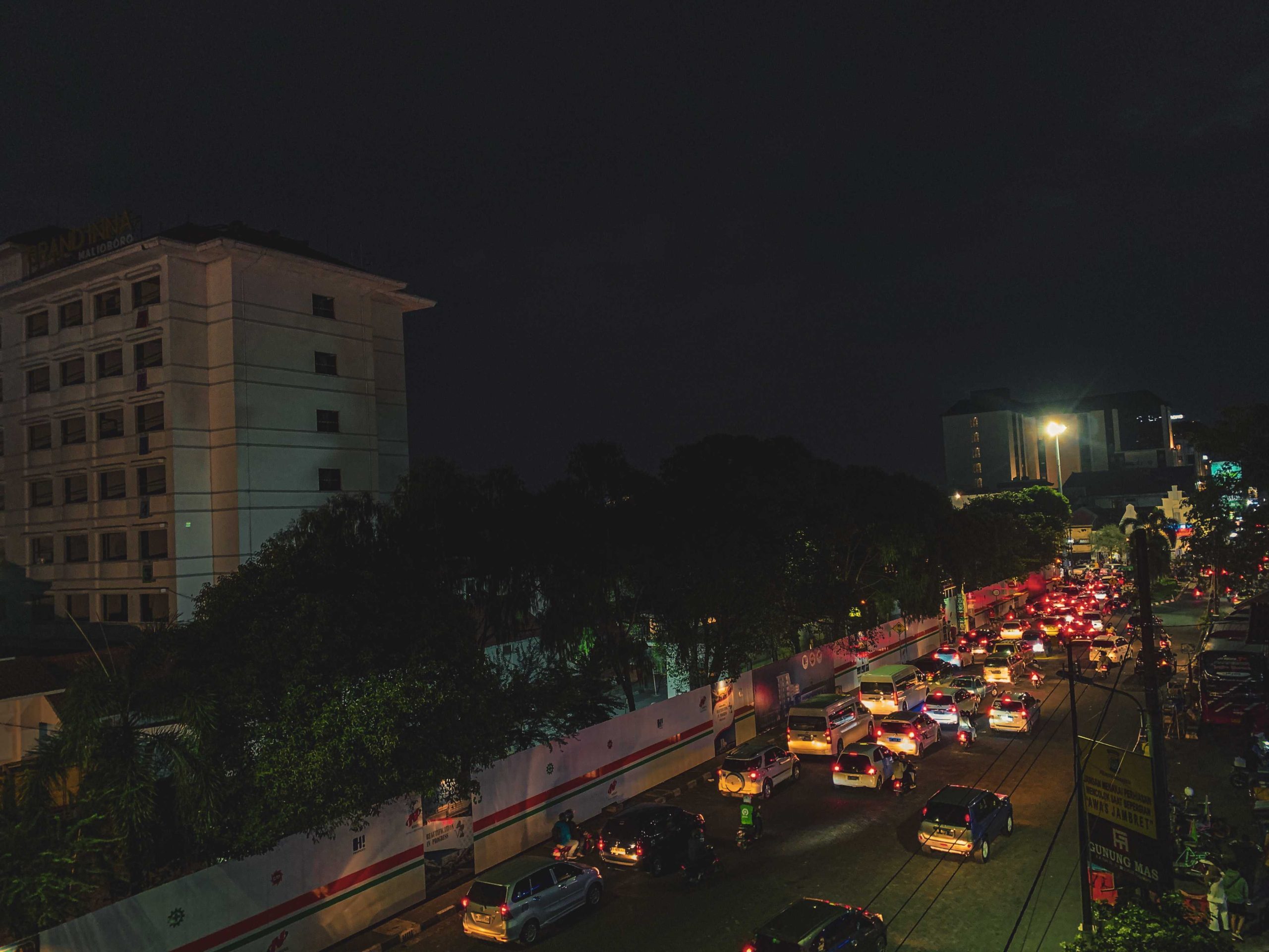 fixed gear cyclist sedang berada di tepi parking lot abu bakar ali melihat keadaan sekitar di tengah kota dengan cahaya city light yang memukau